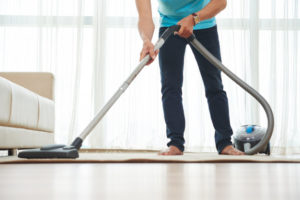 lower-body-shot-unrecognizable-man-vacuuming-carpet-home_1098-17133